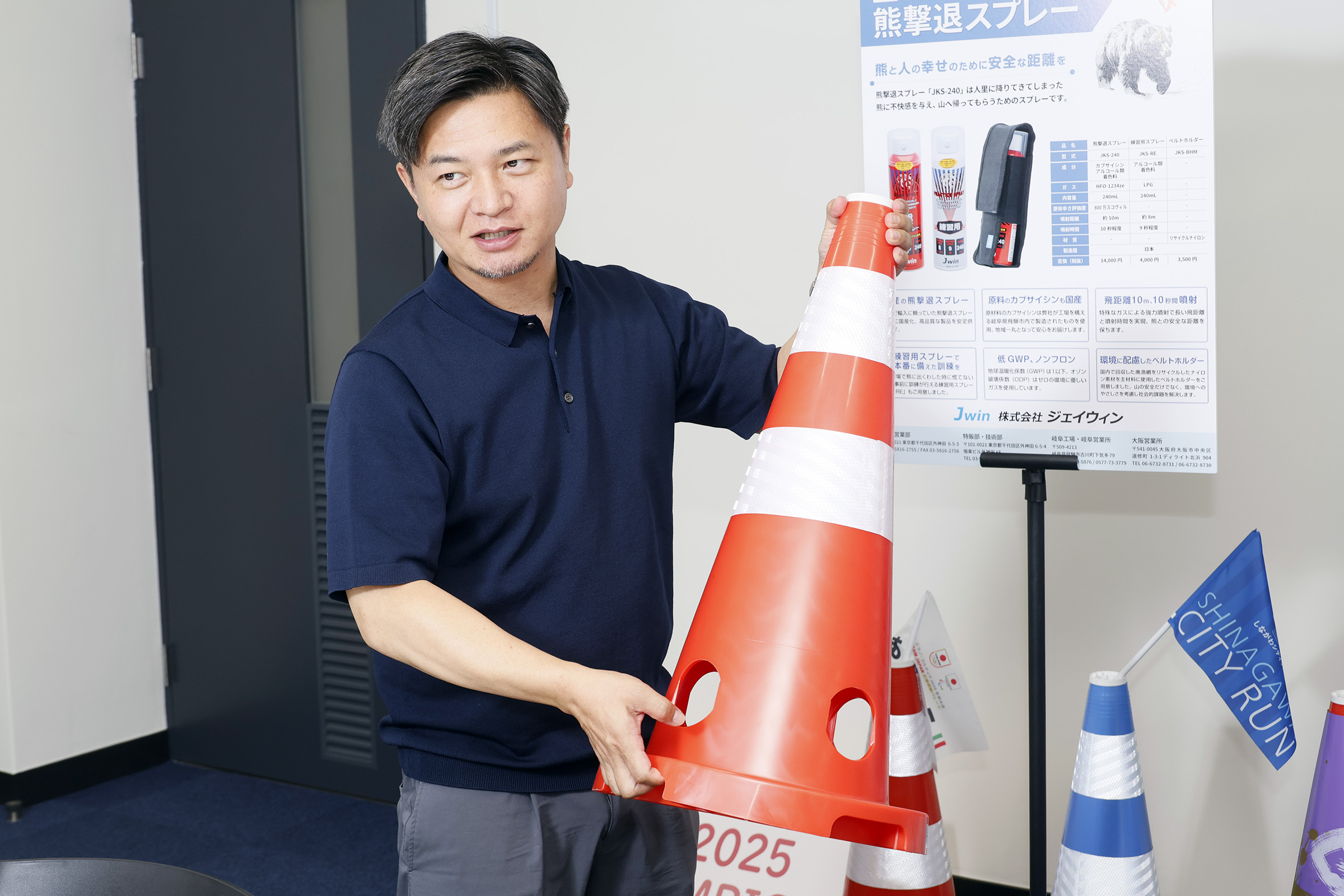 警察向けに工夫された穴あきカラーコーンを説明する様子